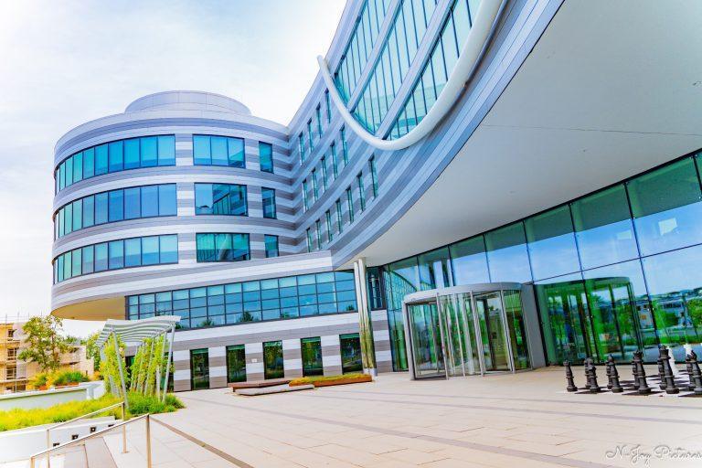 "Moderne architectuur van het AFAS Hoofdkantoor en Experience Center, omringd door groene heuvels en een inspirerende omgeving."