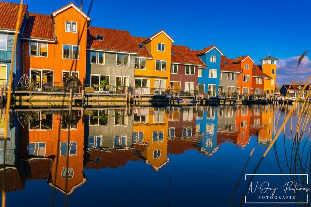 Levendige Plekken van Reitdiephaven Groningen Ontmaskerd! 11 Kleurrijke huisjes aan de Reitdiephaven in Groningen weerspiegelen in het kalme water, met een serene sfeer die perfect is voor stadsfotografie.