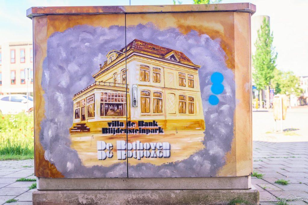 Ontdek 5 Betoverende Plekken met Street Art in Enschede: De Creatieve Hartslag van de Stad! 14 Street art Enschede: De Bank op straatkasten. Bewonder de foto’s en klik door naar de contactpagina!